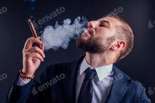 Preview: Portrait of an attractive business man with a cigar in black background studio