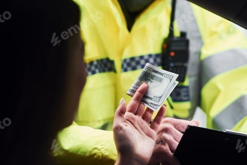 Preview: Male police officer in green uniform checking vehicle on the road. Woman trying to give bribe