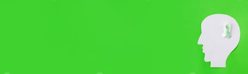 Preview: Brain paper cutout with green ribbon on green background with copy space. Horizontal long banner for