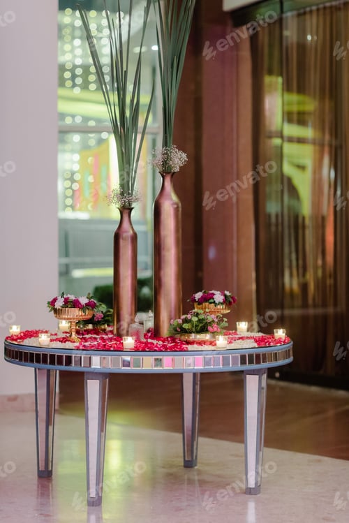 Preview: some tall vases filled with flowers and greenery next to a mirror table