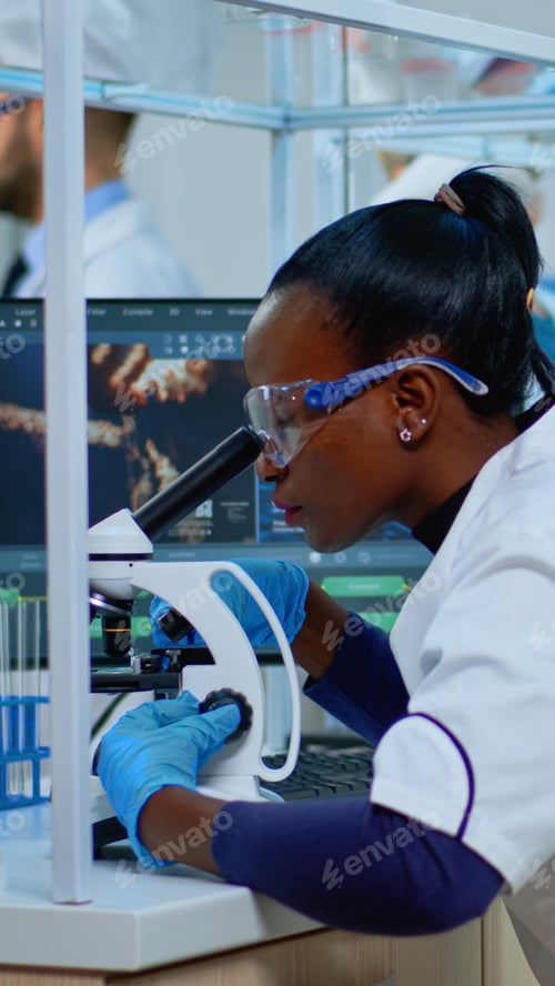 Preview: Black woman chemist analysing reaction of virus on microscope