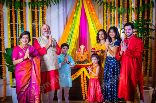 Preview: Indian Asian family performing Ganesh Puja at home in traditional attire, celebrating with devotion