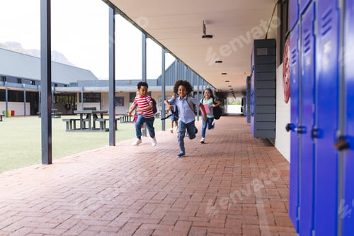 Preview: In school, diverse children are running in the corridor with copy space outdoors