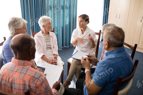 Preview: High angle view of female doctor talking to seniors while sitting on chairs