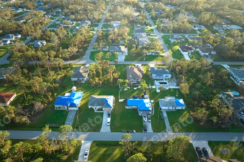 Preview: Top view of leaking house roofs covered with protective tarp sheets against rain water
