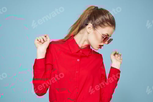 Preview: Woman with dark glasses red lips charm shirt studio blue background