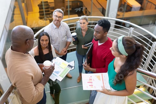 Vista previa: Vista de alto ángulo de profesionales multirraciales que discuten la estrategia mientras están de pie