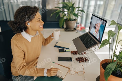 Preview: Stylish business woman have video conference with client and making notes sitting in office