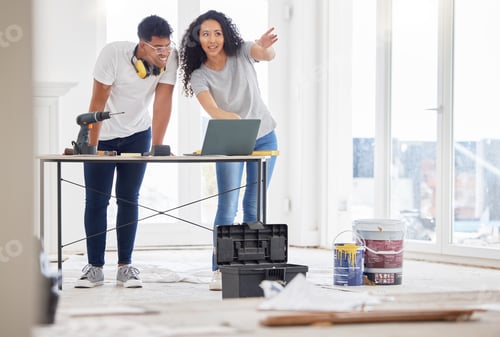 Preview: Shot of a young couple using a laptop while busy renovating a house