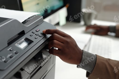 Preview: Hand of young African American man pressing button on panel of xerox