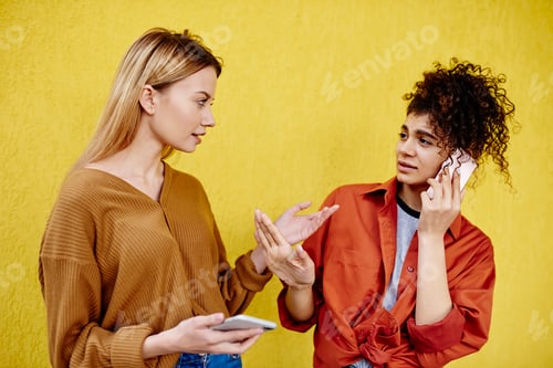 Preview: Thoughtful women talking near bright wall