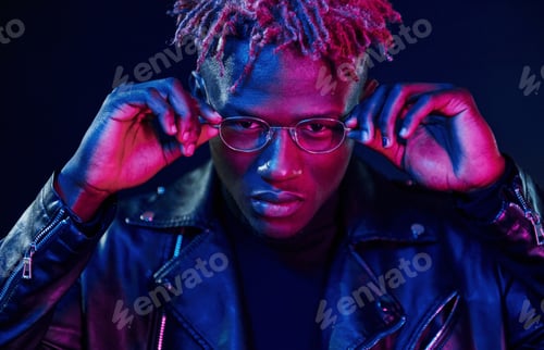 Preview: Having fun. Futuristic neon lighting. Young african american man in the studio