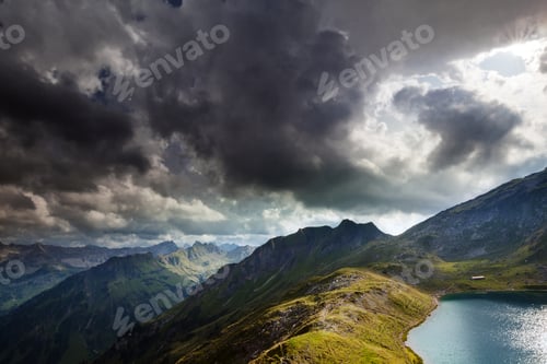 Preview: dramatic sky over alpine lake in mountains