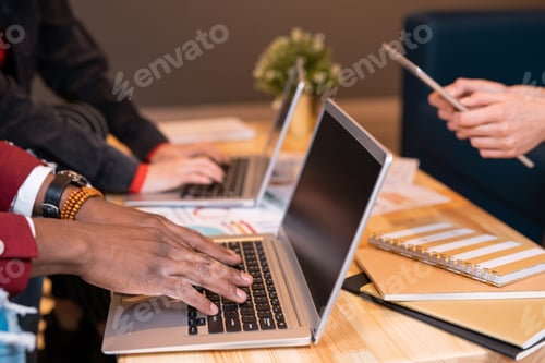Preview: Hands of African guy pressing keys of laptop keypad while preparing for seminar