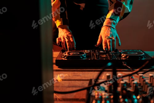 Preview: Female musician using mixing turntables to play music at party