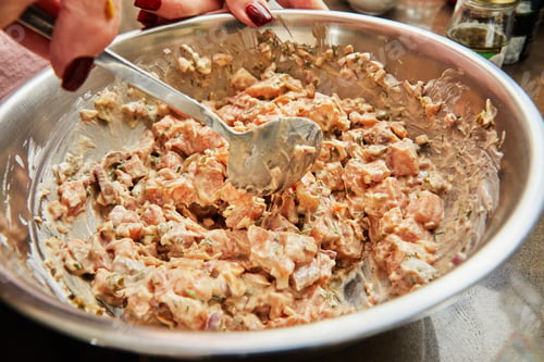 Preview: Chef stirs salmon dish in bowl with spoon