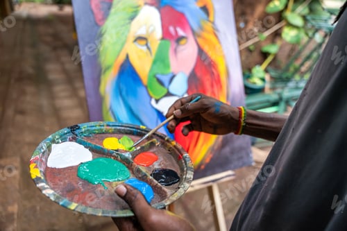 Preview: African painter using brush and palette to paint a picture