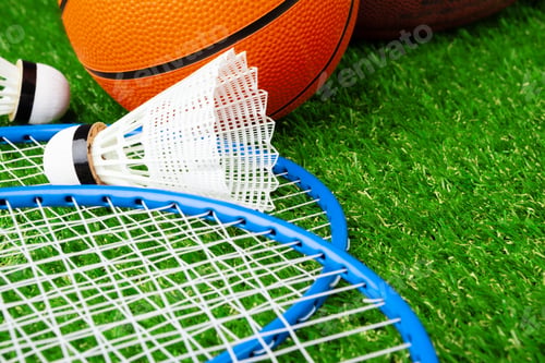 Preview: Badminton game rackets and shuttlecock on grass