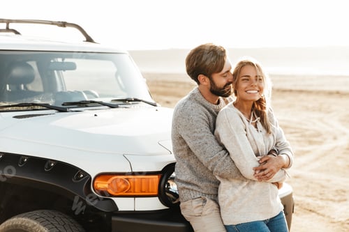 Preview: Loving couple outdoors at beach near car hugging.