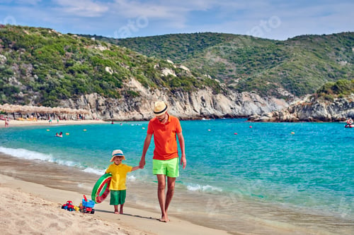 Preview: Two Year Old Toddler Boy Walking On Beach With Father, Holding Inflatable Ring. Summer Family