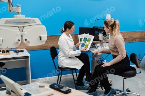 Preview: Keratotopography scan demonstration to girl near slit lamp in ophthalmology clinic