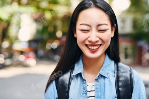 Preview: Portrait of young joyful woman with backpack in the city
