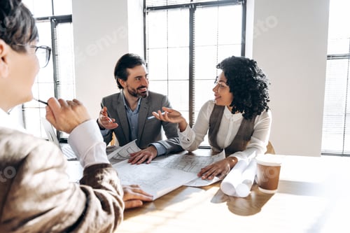 Preview: Architects discussing blueprints during a meeting