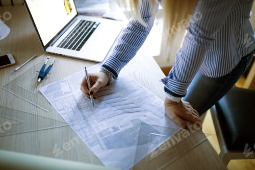 Preview: Young architect working at home drawing plans