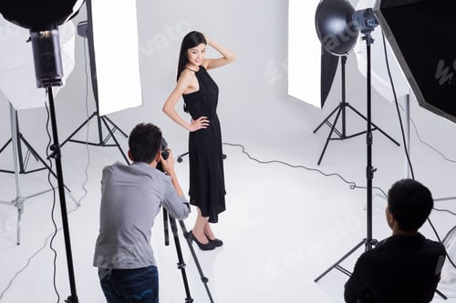 Preview: Photographers taking pictures of female model in studio