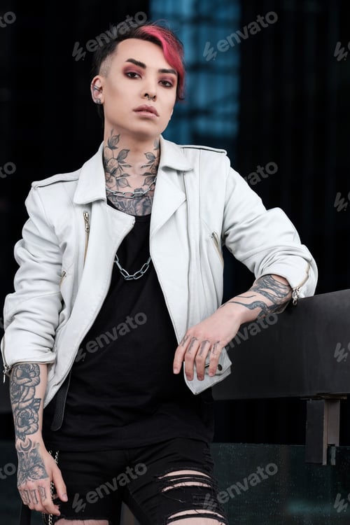 Preview: Confident portrait of androgynous non-binary male looking at camera outdoors.