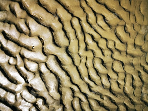 Preview: Closeup shot of wet sand texture with wave lines on the beach in sunny weather