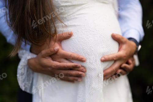 Preview: Tender moment of expectant parents holding pregnant belly in anticipation