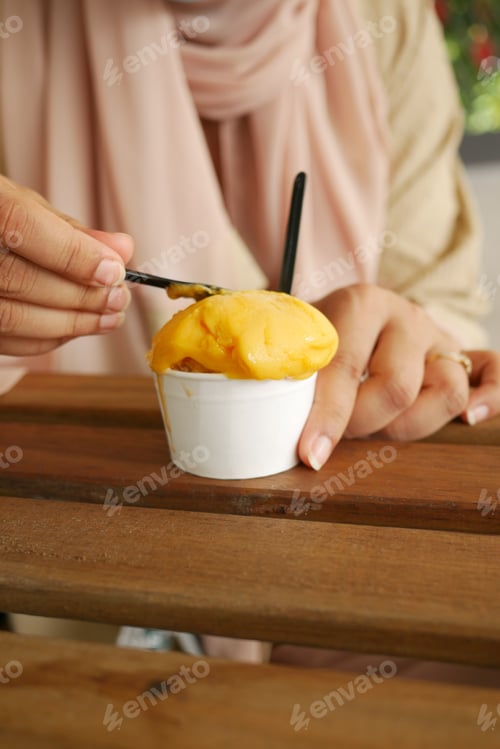 Preview: young women eating mango flavor ice cream