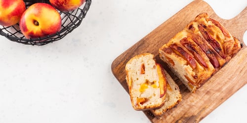 Preview: Peach cake loaf on wooden cutting board on white backgroud