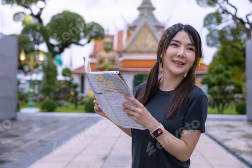 Preview: Tourists Examining Map Near Illuminated Temple