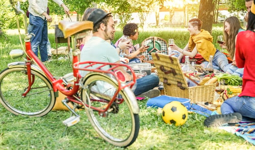 Preview: Happy friends making picnic on city park outdoor