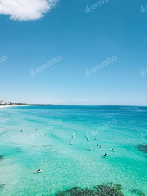 Preview: Scenic view of a sandy beach with bright blue skies and surfers on Trigg Beach in Western Australia