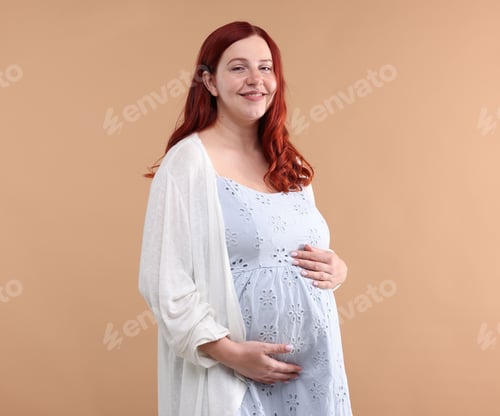 Preview: Portrait of beautiful pregnant woman on beige background