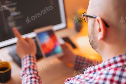 Preview: Male web developer working using tablet and desktop computers