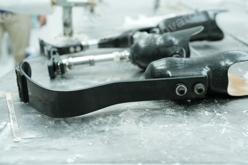 Preview: Orthopedic technician making prosthetic leg for disabilities people in workshop.