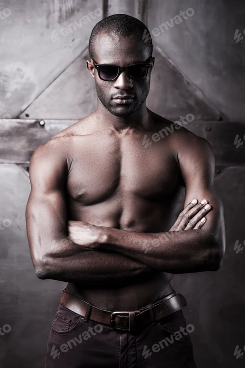 Preview: Cool handsome. Handsome young shirtless African man in sunglasses keeping arms crossed