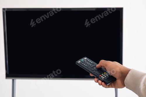 Preview: Black man watching TV and using remote controller