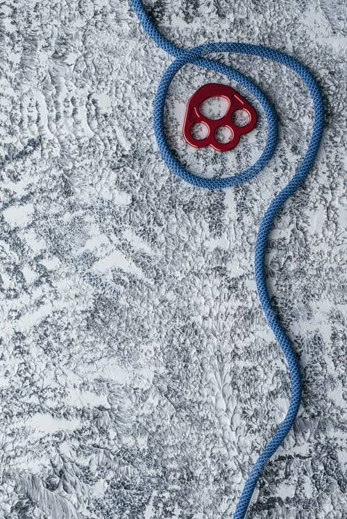 Preview: Isolated photo of climbing equipment. Part of carabiner lying on the white and grey colored table