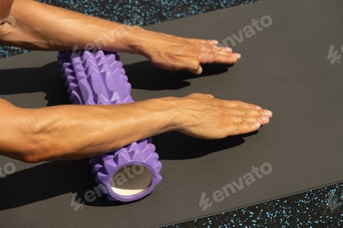 Preview: Athlete man stretching arms on foam roller on sports ground. Outdoor. Morning routine.
