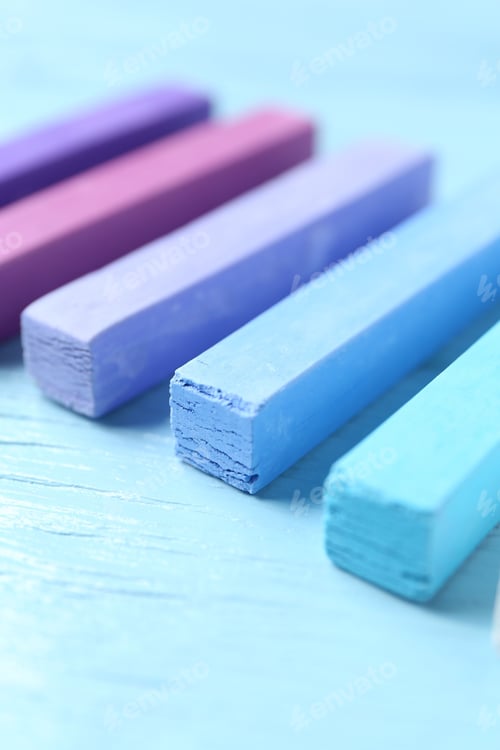 Preview: Colorful chalk pastels on light wooden table, closeup