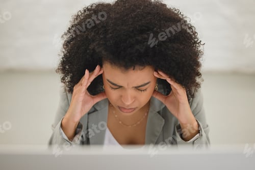 Preview: Young mixed race businesswoman suffering from a headache while working on a desktop computer in an
