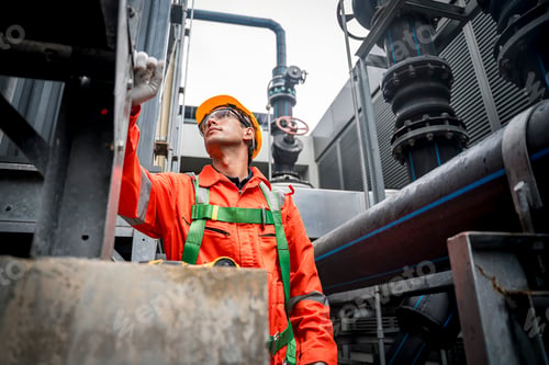Preview: Construction worker inspecting machinery at an industrial site during daylight hours