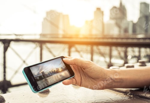 Preview: Woman watching photo of New york city skyline on the smart phone.