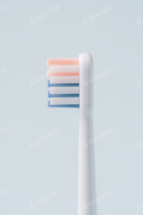 Preview: Electric toothbrush head in profile against blue background
