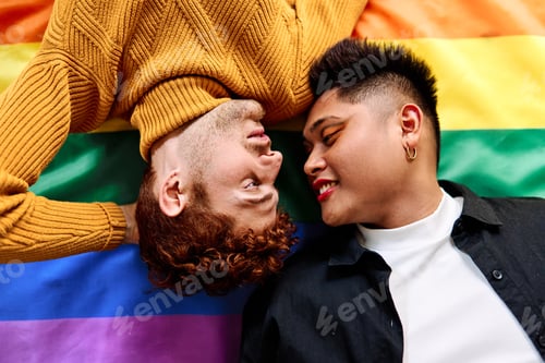 Preview: Tender gay couple lying on a lgtb rainbow flag